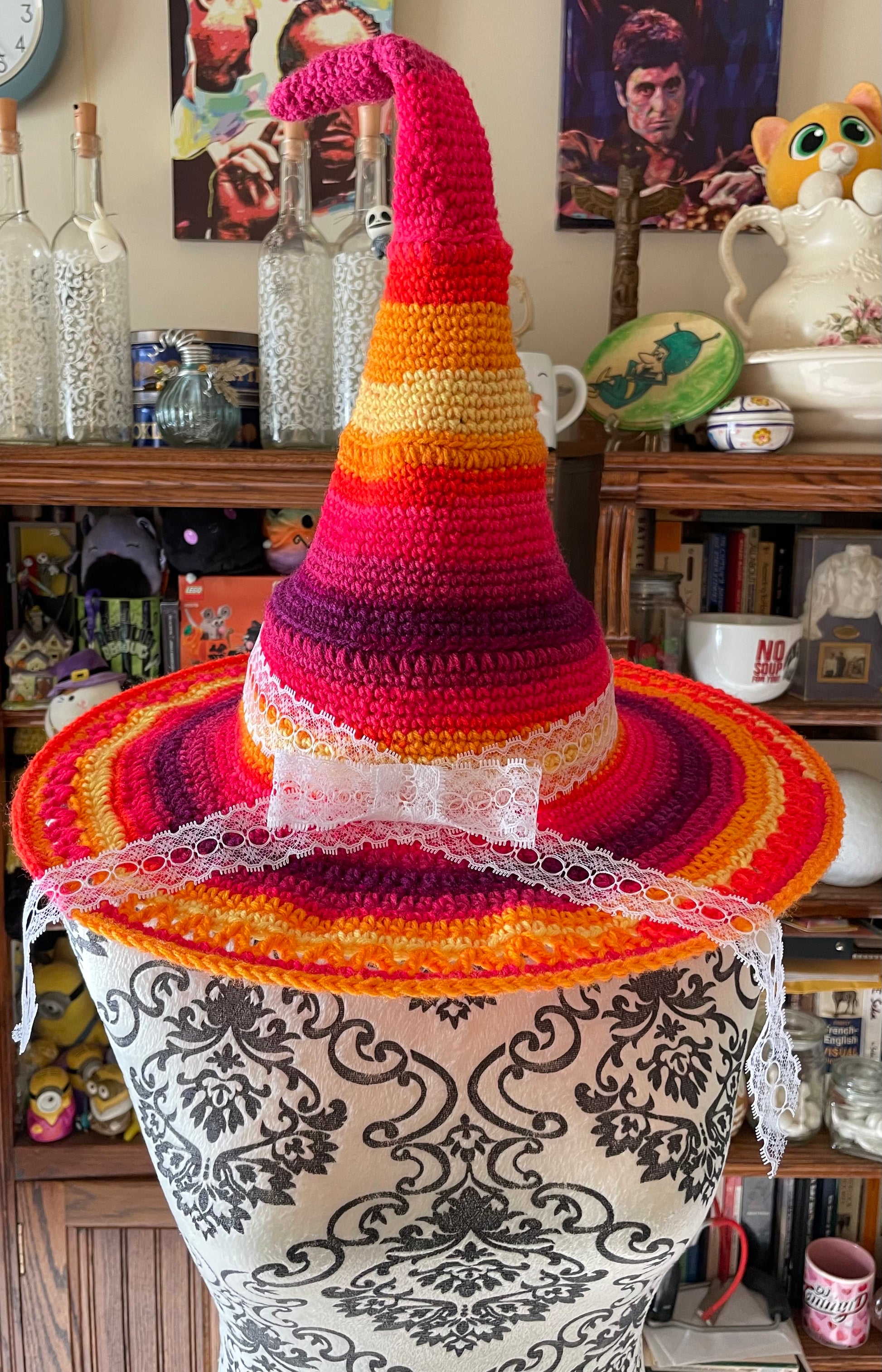 Colorful knitted hat on a decorative pot with a cozy indoor setting in the background.